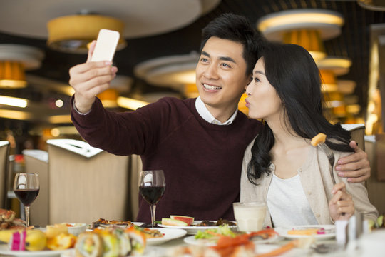 Cheerful young Chinese couple having buffet dinner