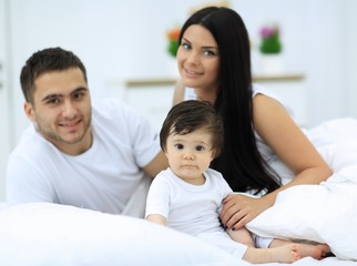 Fototapeta premium Cheerful family having fun together lying on a bed