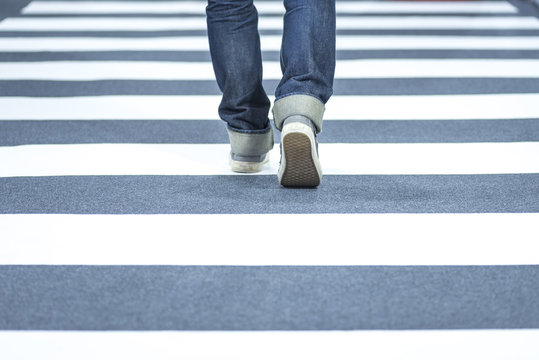 Man wear jeans walk across the street on the crosswalk
