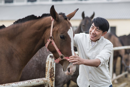 Cheerful young Chinese man and horse