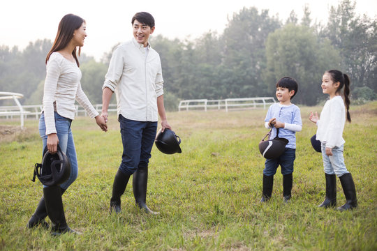Cheerful young Chinese family on grassy field