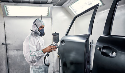 Painting the car in black color in the paint chamber on the service..