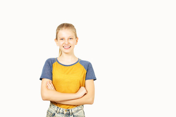 Fototapeta premium Young beautiful teenage girl with blond hair in ponytail wearing yellow baseball t-shirt with blue sleeves. Pretty female smiling with folded hands standing on isolated white background w/ copy space