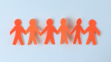 four paper men taking each other's hands