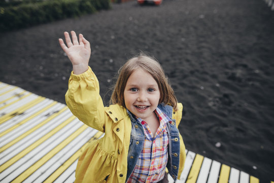 Portrait of smiling little girl on boardwalk on black lava beach