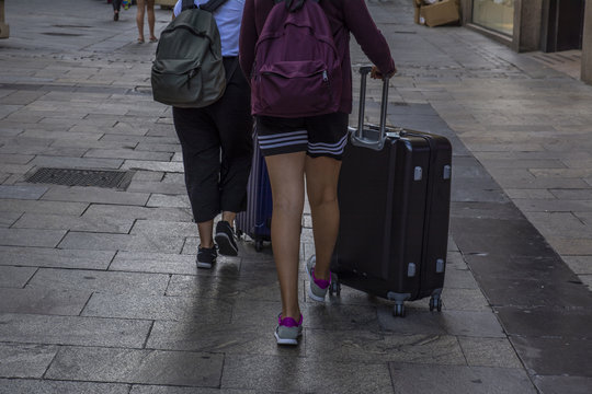dos turistas con sus maletas por la ciudad 