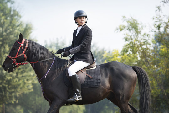 Young Chinese man riding horse 