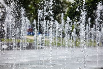 Splashing water from a fountain in the park as a background