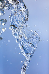 Fototapeta na wymiar Splashing water with drops on the sky background