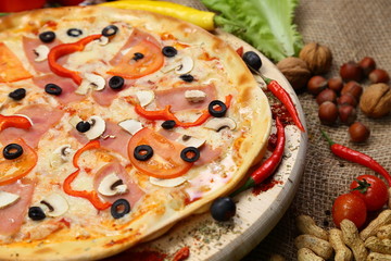 pizza thin olives sausage mushrooms pepper on a wooden stand