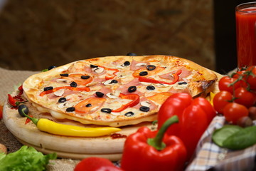 pizza thin olives sausage mushrooms pepper on a wooden stand