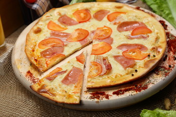 Pizza thin with sausage, bacon, spices