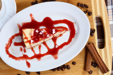piece of cheesecake cake with jam, jam and a cup of coffee with cream