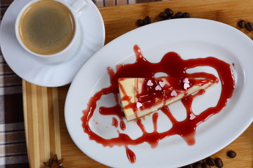 piece of cheesecake cake with jam, jam and a cup of coffee with cream