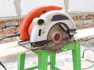 A new modern circular saw on the background of construction.
