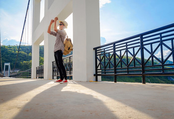 Asian man backpack standing alone on bridge