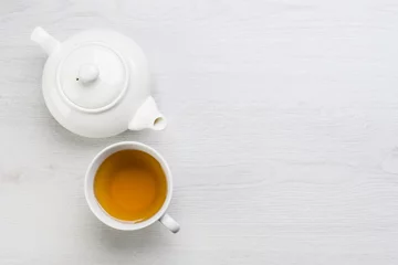Papier Peint photo autocollant Theé teapot and cup of tea on white table