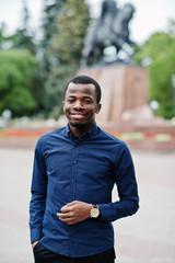 African  man posed at street of city wear on blue shirt and black pants.