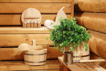 Fototapeta na wymiar Fresh birch broom on the wooden bucket and bath accessories.