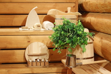 Fototapeta na wymiar Fresh birch broom on the wooden bucket and bath accessories.