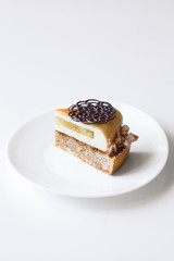 Contemporary Apple, Caramel and Hazelnut Mousse Cake, on white background. 