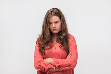 Beautiful plump girl with long hair frowning her face in displeasure. She is offended on her boyfriend. He forgot about a date.