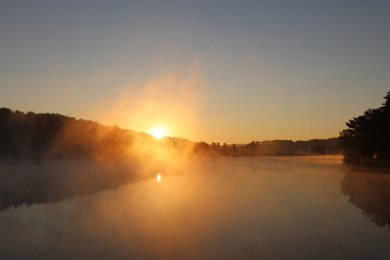 Sunrise over misty lake