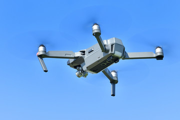 青空を背景に飛ぶドローン