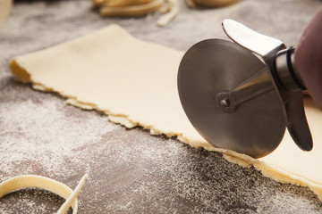 Chef using wheel cutter in preparation of pasta