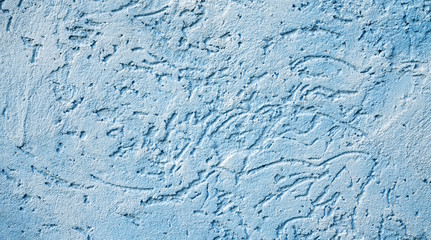 The blue texture of the surface of the wall covered with decorative plaster of the woodworm type, close-up architecture abstract background