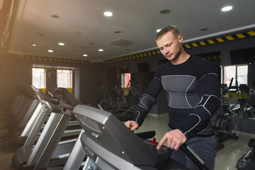 Fototapeta na wymiar Man in gym running on treadmill
