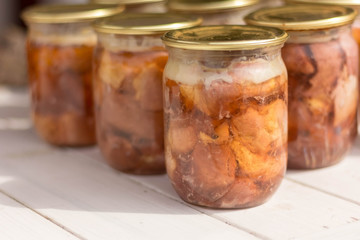 Canned meat in a glass jar on a white wooden table