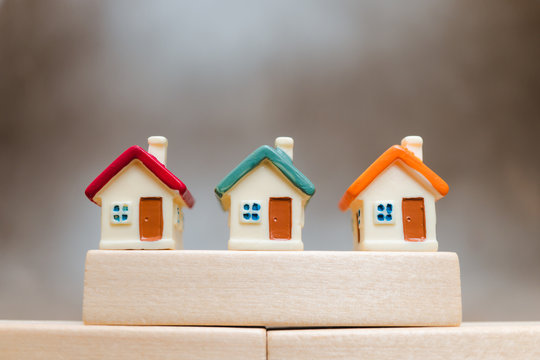 Miniature colorful house on wooden block using as property and business concept