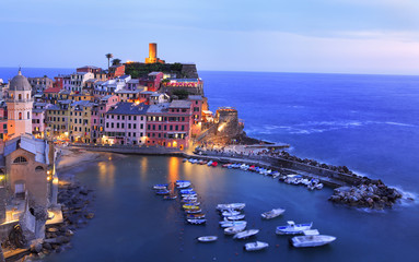 Aerial view of Vernazza vilagge illuminated at dusk on Mediterranean coast, Cinque Terre, Italy