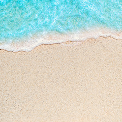 Fototapeta na wymiar Soft wave of blue ocean on sandy beach with copy space fr text. Summer Background.