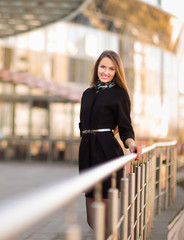 Fototapeta premium young female employee of a company is standing near a modern office