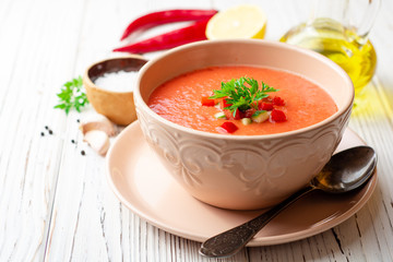 Gazpacho soup in bowl on white wooden background. Traditional spanish dish.