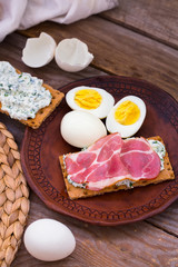 Rustic jamon breakfast composition on old retro wooden table.