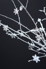 Home decor, modern minimalist interior decoration, season specific with copy space white tree branches with snow flakes on black background
