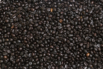 background of a group of dark brown roasted coffee beans
