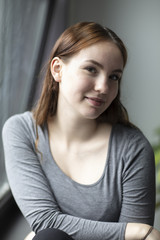 Beauty Portrait of a Young Woman Smiling Seated by Window