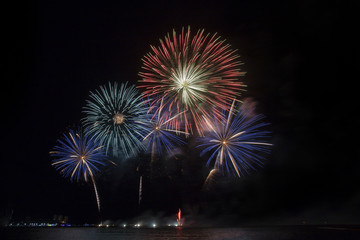 Festive beautiful colorful fireworks display on the sea beach, Amazing holiday fireworks party or any celebration event in the dark sky