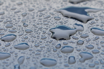 Raindrops on a dark blue car . Rain drops background