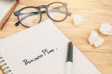Businessman Writing Business Plan on book. Business team planning their work.