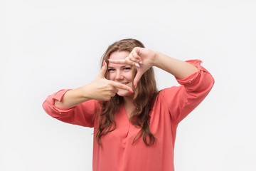 Young caucasian female in red shirt blogger plans how to shoot her new project. Study to make professional photos.