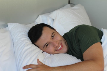 Good looking ethnic man smiling in bed