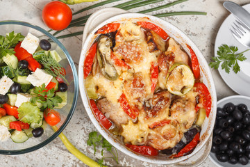 Traditional tasty rustic stew of chicken and vegetables  with Greek salad and black olives