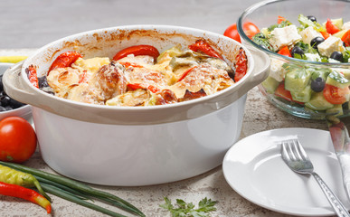 Traditional tasty rustic stew of chicken and vegetables  with Greek salad and black olives