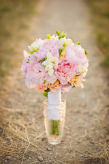 Pink paeonia bouquet in a glass vase outdoors