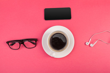 Coffee, sunglasses, smartphone and earphones on pink background top view